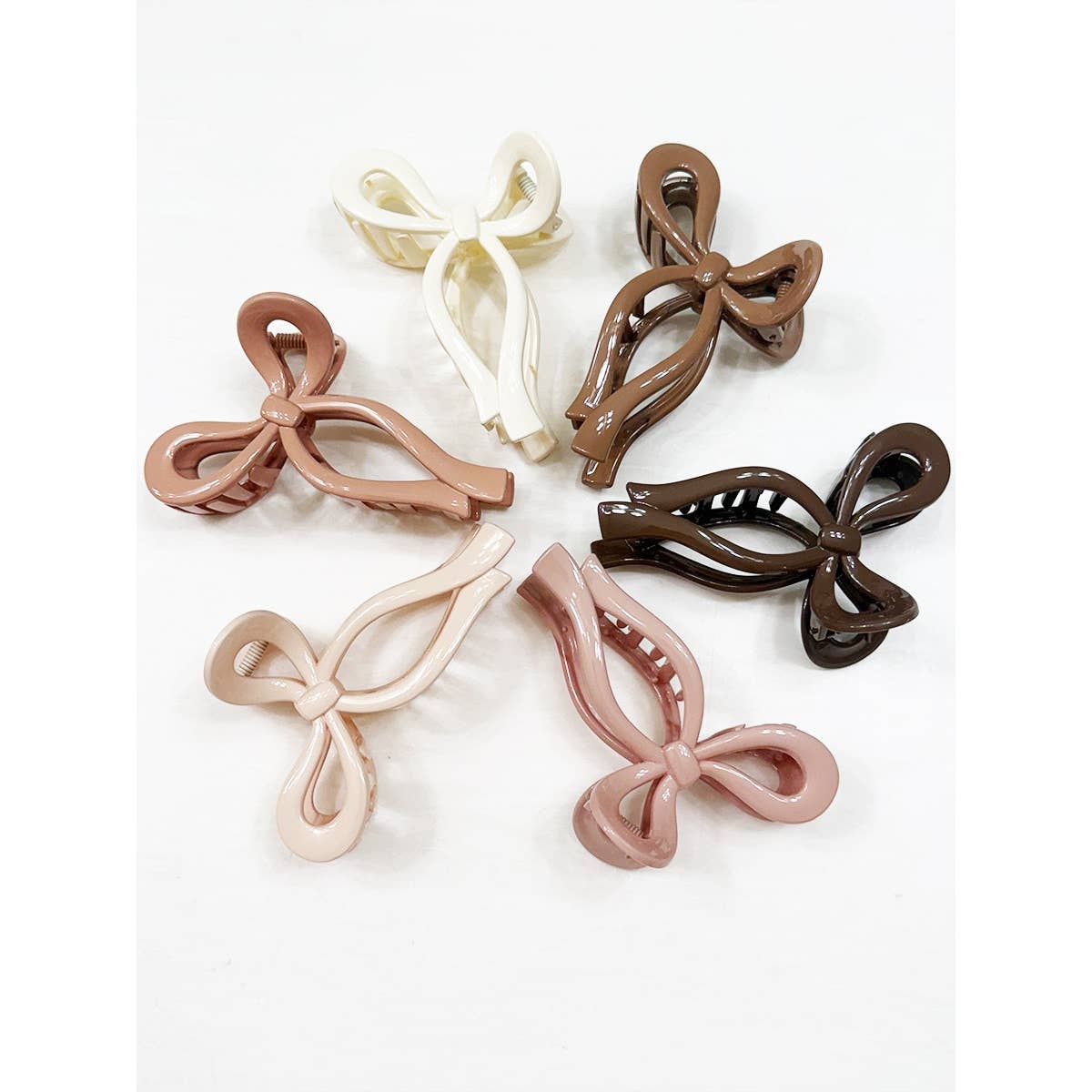 Set of five bow-shaped hair clips in different colors on a white background