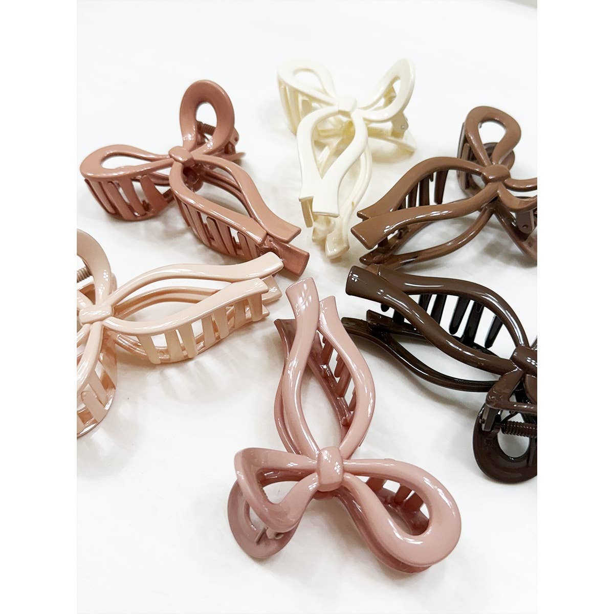 Set of bow-shaped hair clips in various colors on a white background